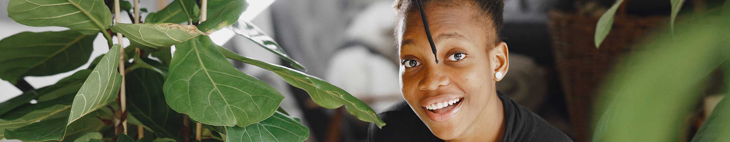 Girl smiling and looking happy with greenery around her