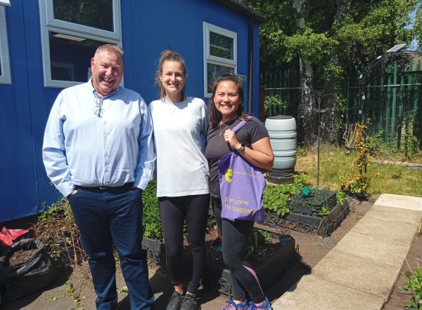 Two corporate volunteers in garden with Chris, CEO of Eikon