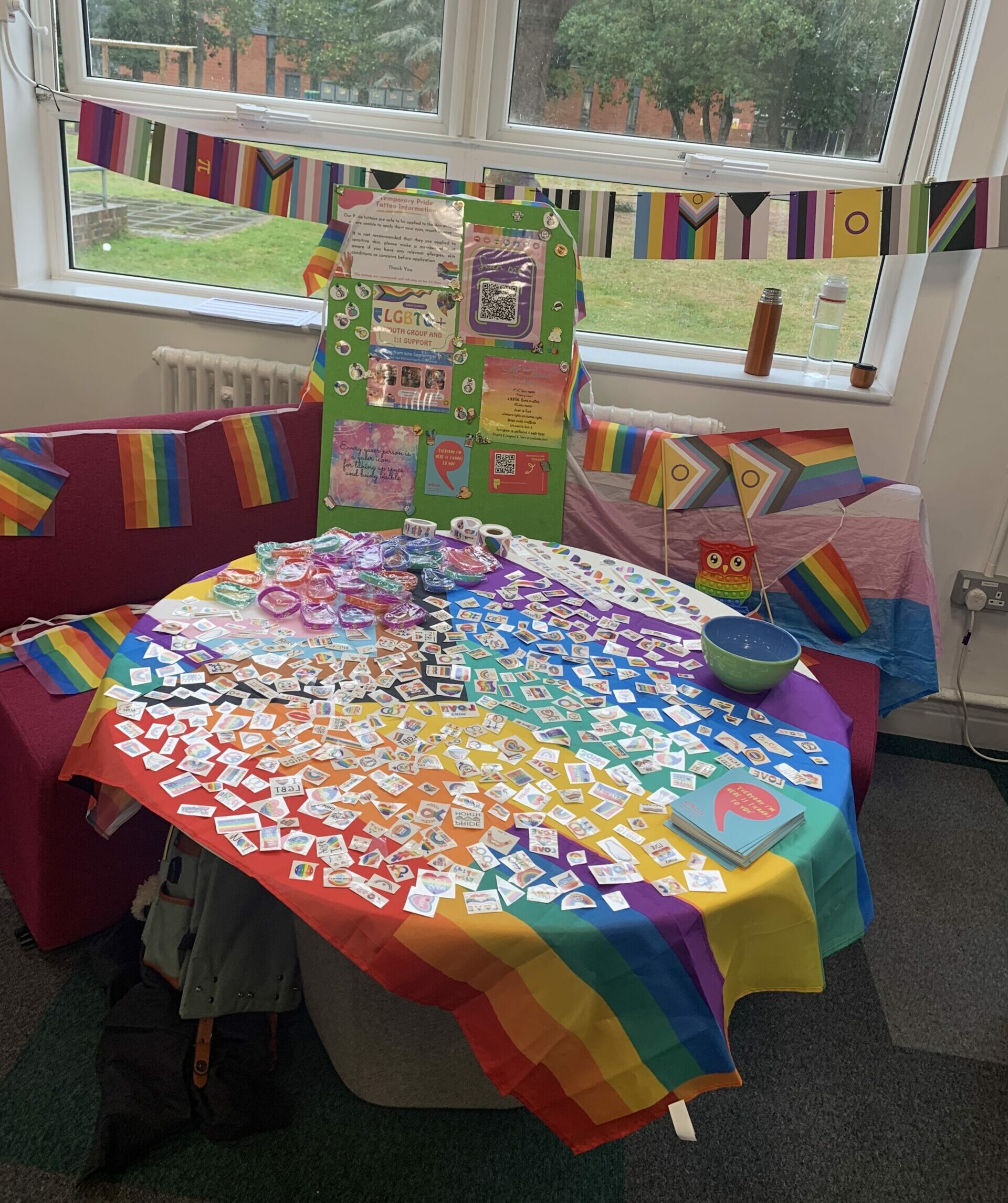 LGBTQ+ information table covered in leaflets and stickers