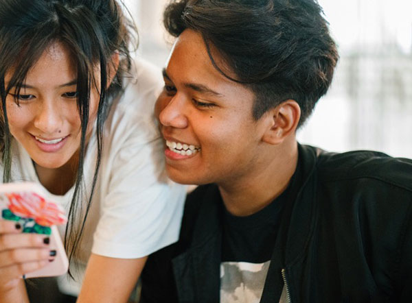 Two teenagers looking at a phone